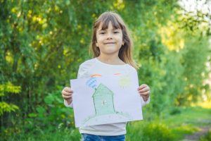 Girl Holding House Drawing